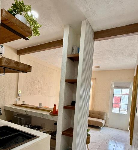 a kitchen with a column in the middle of a room at Kinara merida yucatan con alberca y jacuzzi privado in Mérida