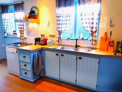 a kitchen with white cabinets and a sink at Het Vissershuisje in Edam
