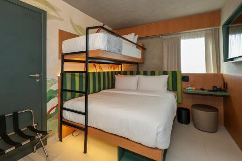 a bedroom with a bunk bed with white sheets at Motto By Hilton Recife in Recife