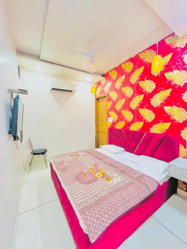 a bedroom with a bed with a red and yellow painting at Hotel RKS Residency in Bathinda