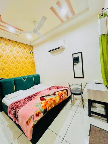 a bedroom with a bed and a table and a chair at Hotel RKS Residency in Bathinda