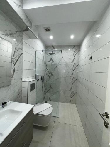 a bathroom with a toilet and a sink and a shower at Ajsel Luxury Rooms in Sarandë