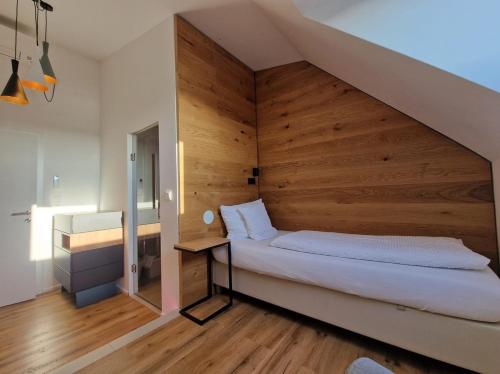 a bedroom with a bed with a wooden wall at HOTEL MARIA in Gramatneusiedl