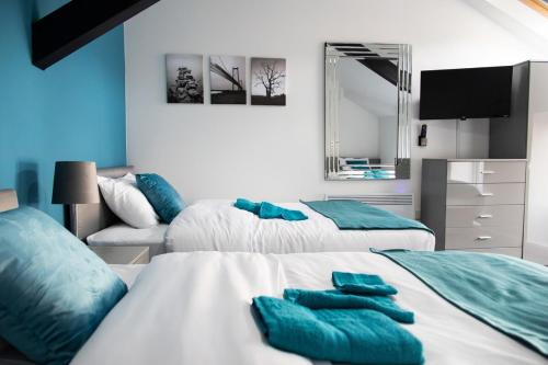 a bedroom with two beds with blue pillows on them at Luton Grove in Liverpool