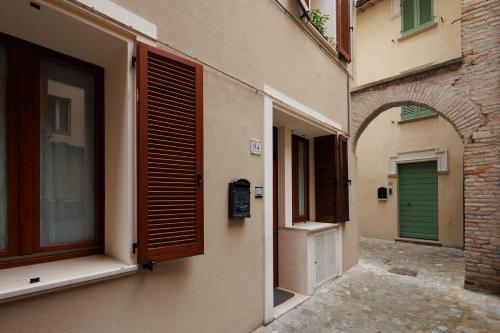 an alley between two buildings with green doors at Brezza della Fortuna in Fano