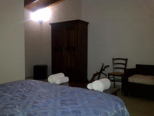 a bedroom with a bed and a cabinet and a chair at La Quercia in Arbus