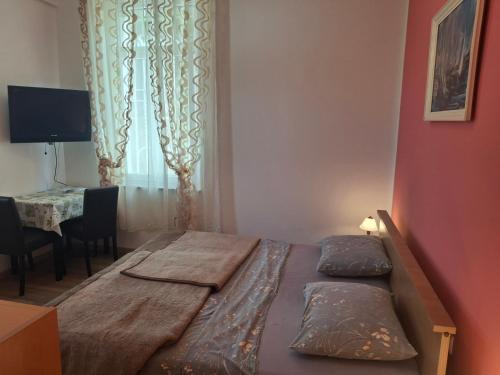 a bedroom with a bed with two pillows on it at Tivoli Apartment in Ičići