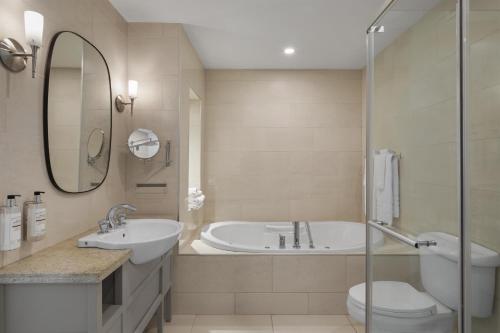 a bathroom with a tub and a toilet and a sink at Best Western Premier Hotel Aristocrate in Quebec City