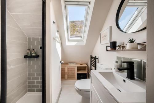 a bathroom with a toilet and a sink and a mirror at The TreeHouse Hideaway in Shrewsbury
