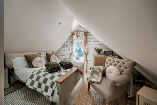 a bedroom with a bed and a couch in a attic at The TreeHouse Hideaway in Shrewsbury