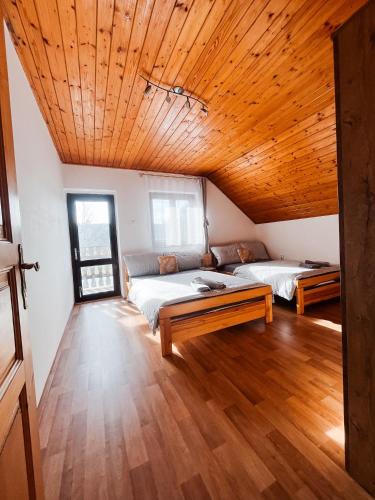 two beds in a room with a wooden ceiling at Apartmány Ve Mlejně in Čachrov