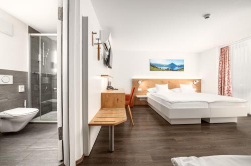a hotel room with two beds and a bathroom at Hotel Bernerhof in Interlaken
