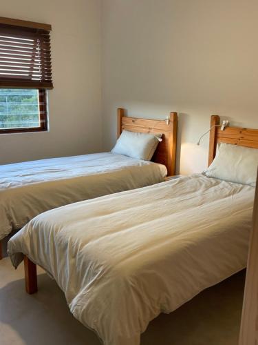 two beds sitting next to each other in a room at River House at Rivierplaas in Stilbaai