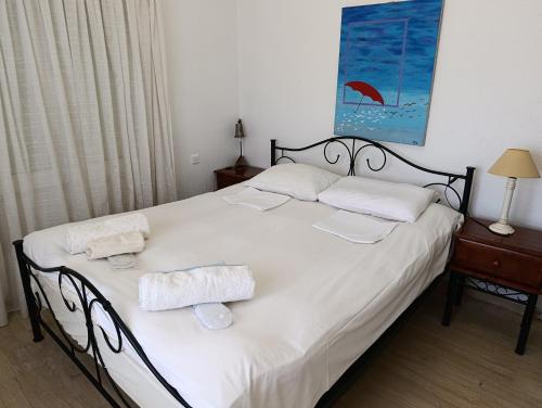 a bedroom with a bed with two towels on it at Surf House in Artemida