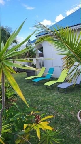 a group of chairs sitting in a yard next to a building at Villa Créole Alamanda in Petite Île