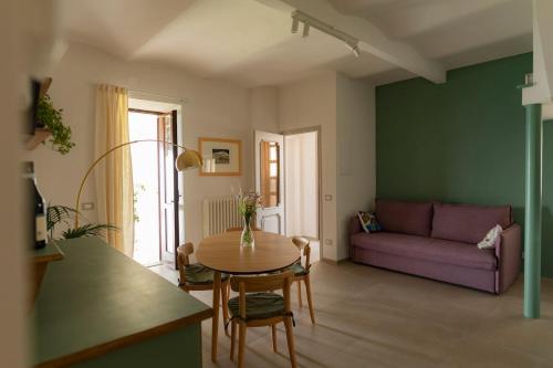 a living room with a table and a purple couch at Sky & Vineyards - Melograno - in La Morra