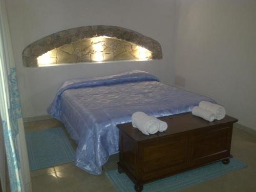 a bedroom with a bed with two towels on a table at La Quercia in Arbus