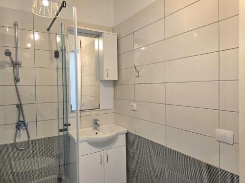 a white bathroom with a sink and a shower at Wide Beach Apartments 236 in Mullini i Danit