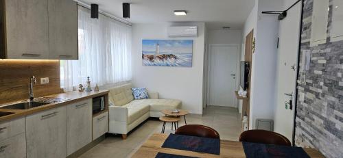 a kitchen and living room with a couch and a table at APARTMANI SUNSIDE NIN in Nin