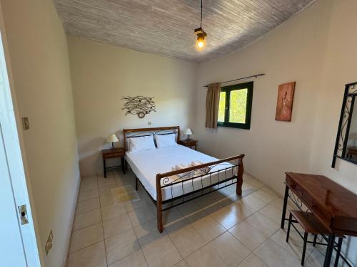 a bedroom with a bed and a desk and a piano at Razos Windmill in Vathi