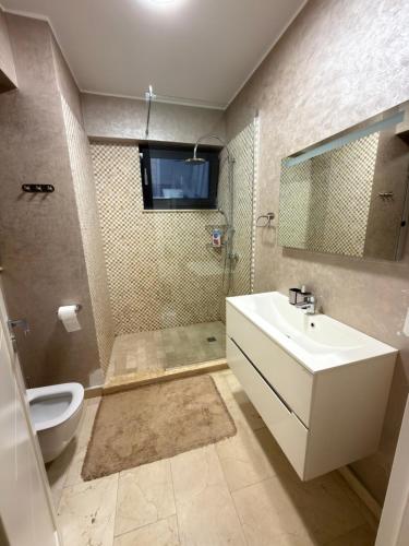 a bathroom with a white sink and a toilet at Sophia Luxury Residence in Mamaia