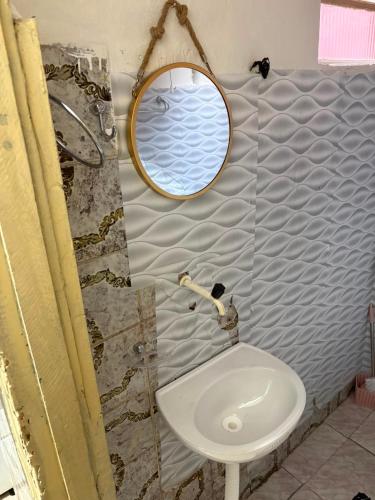 a bathroom with a sink and a mirror at Casa a 3 minutos da basilica in Aparecida
