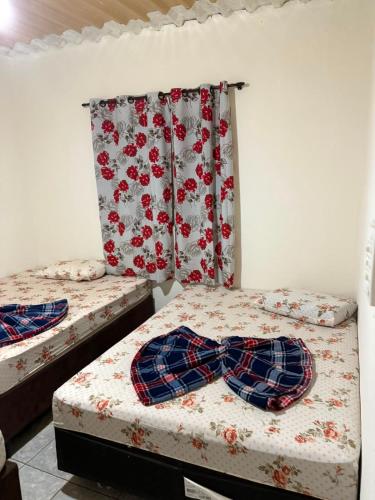 two beds in a room with ties on them at Casa a 3 minutos da basilica in Aparecida