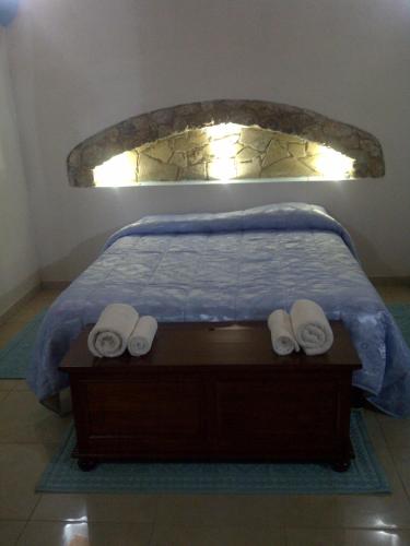 a bed with two white towels on a wooden table at La Quercia in Arbus