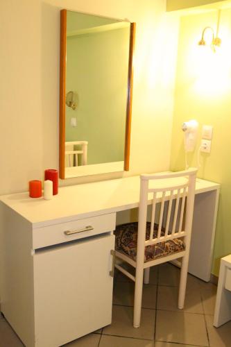 a bathroom with a white vanity with a mirror and a chair at Mediterranean Blue in Kavos
