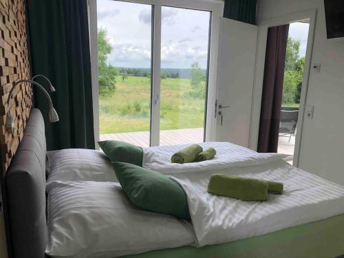 a bed with two pillows and a large window at Cottage2Rest in Erbach