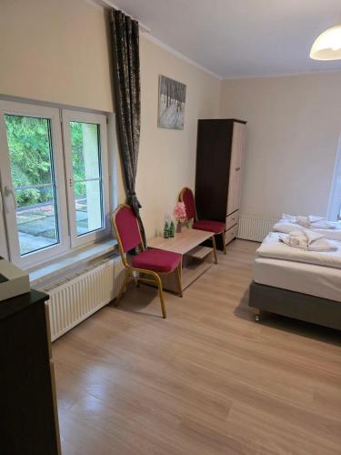 a bedroom with two chairs and a bed and windows at Krokusowa Przystań-SPA,Restauracja i Noclegi w Górach Sowich in Rzeczka