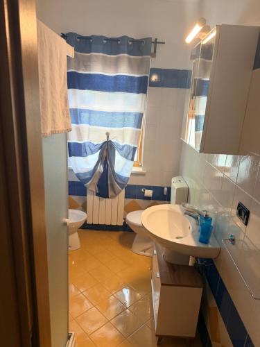 a bathroom with a sink and a toilet and a window at Casa Vacanze Cau de Mezo in Marina Julia