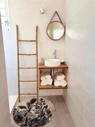 a bathroom with a sink and a shelf with towels at Villa neuve Casa Helena - Piscine privée et jardin - 6 pers - Saint-Esprit - Sud Martinique in Quartier Palmène