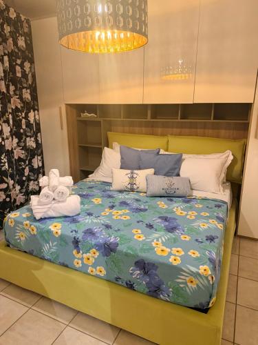 a bed with a blue comforter with towels on it at Casa Vacanze Cau de Mezo in Marina Julia