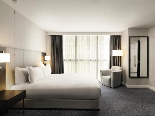 a hotel room with a large bed and a chair at Sofitel London Gatwick in Horley