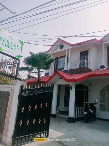 a house with a motorcycle parked in front of it at Serene Lodge in Shillong