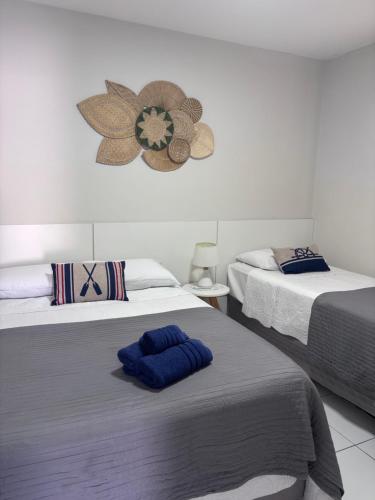 a bedroom with two beds and a clock on the wall at Casa Blanca in Galinhos