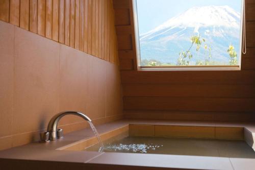 a bathroom with a sink and a window with a snow covered mountain at THE THIRD PLACE Mt Fuji in Fujikawaguchiko