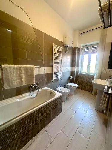 a bathroom with a tub and a toilet and a sink at Lincoln B&B in Caserta