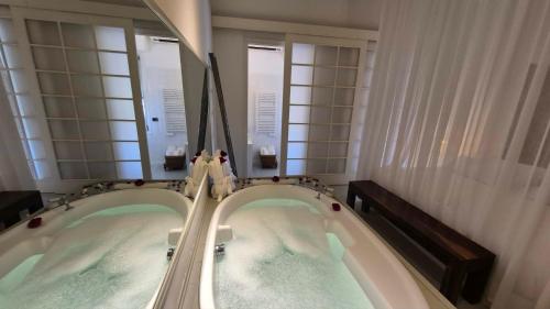 two jacuzzi tubs in a bathroom with two mirrors at Eveline Portosole Hotel in Sanremo