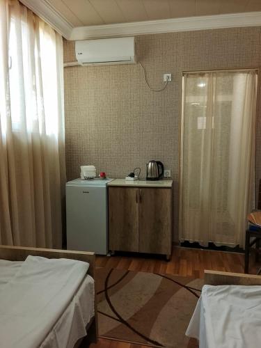 a room with two beds and a kitchen with a refrigerator at temuri Room 558-58-78-27 in Poti