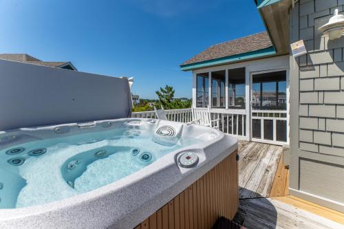 a hot tub on the deck of a house at Into the Sun - Corolla, Villages at Ocean Hill, 75 Yds to Beach, Hot Tub, Community Pool, Pets OK, Flex Stays in Corolla