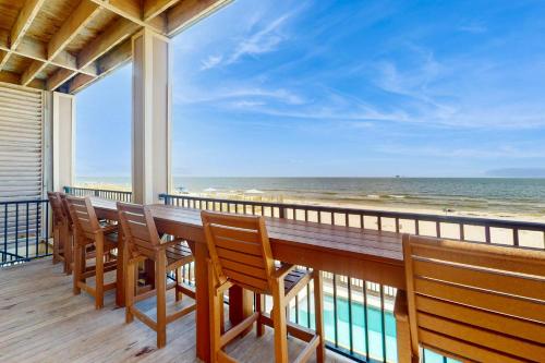 a balcony with a table and chairs on the beach at Luxury Beachfront Duplex in Fort Morgan - Pool Elevator and Wedding-Friendly in Gulf Shores