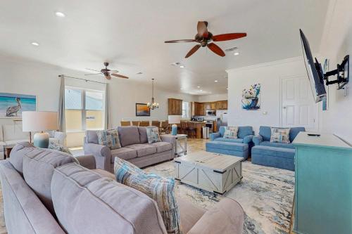 a living room with couches and a ceiling fan at Luxury Beachfront Duplex in Fort Morgan - Pool Elevator and Wedding-Friendly in Gulf Shores