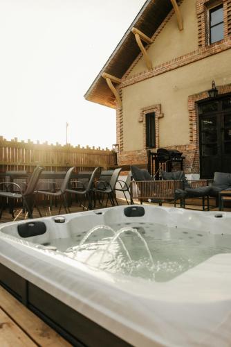 a hot tub on a patio with chairs and a piano at Moulin de Micheline - Jacuzzi - Vue Exceptionnelle in Bourg-dʼIré