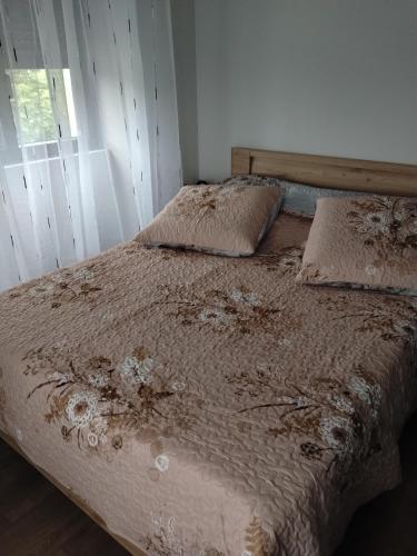 a bed in a bedroom with a white wall at Une pause au pied des Pyrénées in Asson