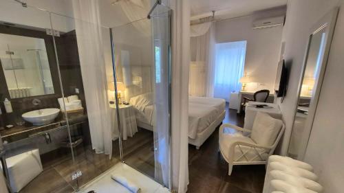 a hotel room with a bathroom with a bed and a shower at Eveline 2 - Piscina Privata o Jacuzzi in Sanremo