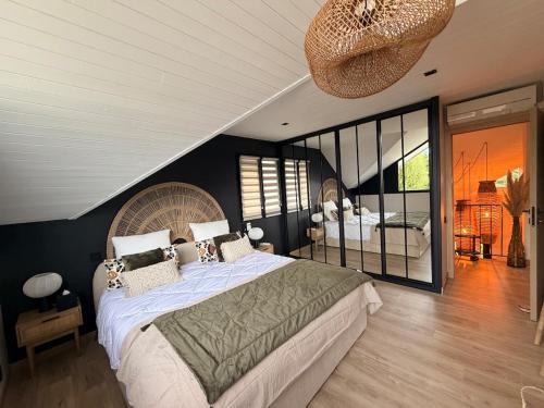 a bedroom with a large bed and a balcony at La Maison Du Lac in Doussard