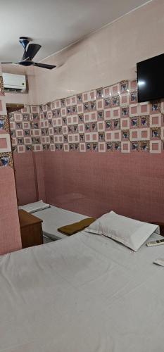 a room with a bed and a wall with pictures at JSM DELUXE Ac in Vellore