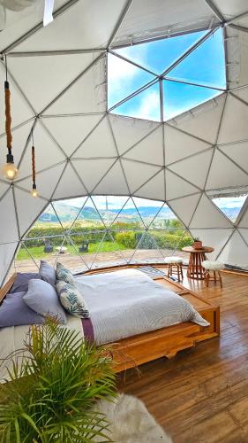 a bedroom with a large bed in a tent at Amatea de Villa de Leyva in Villa de Leyva